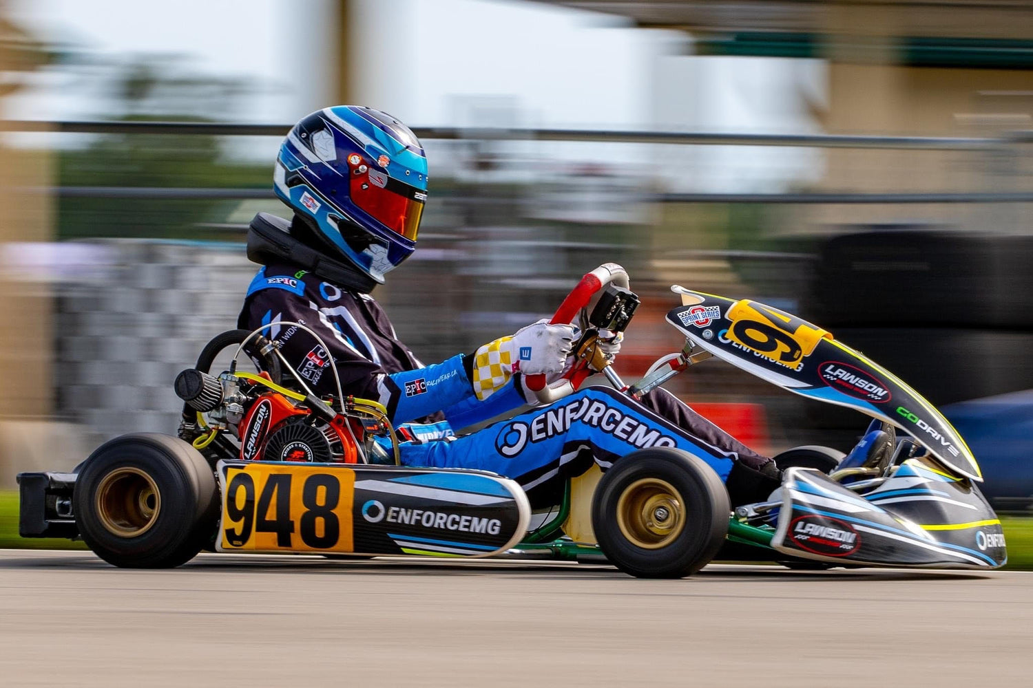 EnforceMG Sponsored Professional Kart Racer, Keegan Widmyer, Races Down the Front Straight at the Pittsburgh International Race Complex in His Blue, Black, and White EnforceMG Kart.